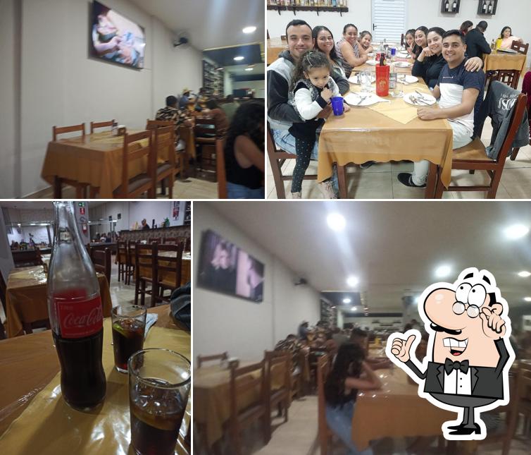 Sente em uma das mesas no D' Menor Restaurante & Pizzaria
