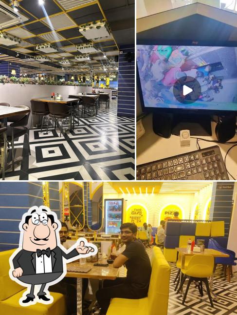 Take a seat at one of the tables at Samjohn's Pizza As Rao Nagar