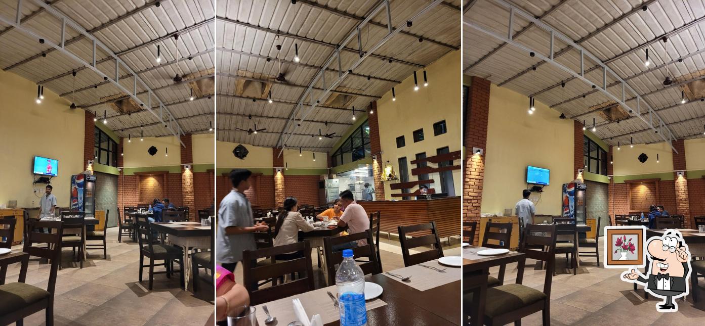 Take a seat at one of the tables at Radhe Krishna Restaurant