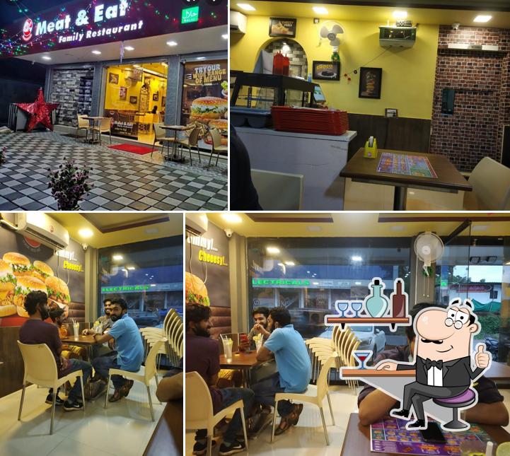 Take a seat at one of the tables at Meat & Eat Friedchicken/Biryani/Premium Burgers
