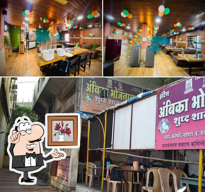 Take a seat at one of the tables at Hotel Ambika Veg Family Restaurant