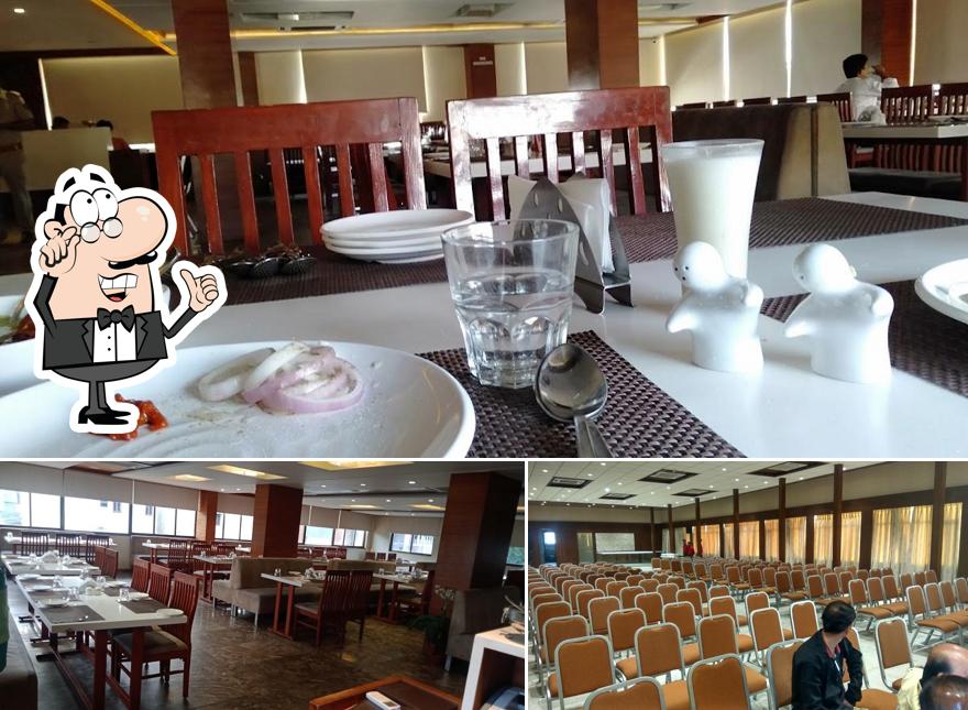 Take a seat at one of the tables at Hotel Utsav And Restaurant