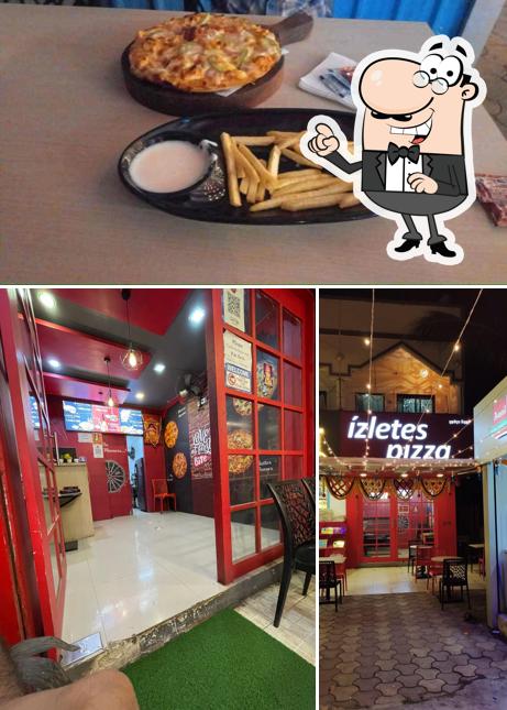 Take a seat at one of the tables at Izletes Pizza (Pure Veg)