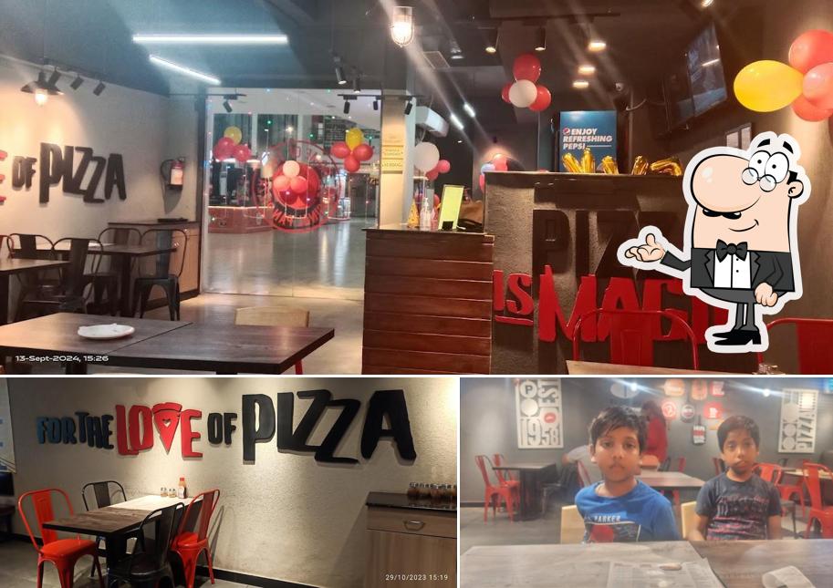 Take a seat at one of the tables at Pizza Hut Genesis Mall, Alwar