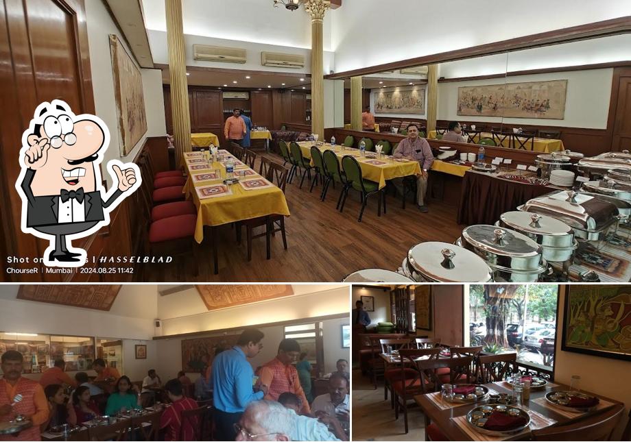 Take a seat at one of the tables at Chetana Veg. Restaurant & Bar (1946)