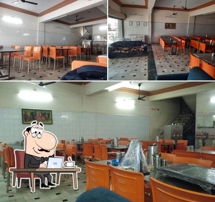 Take a seat at one of the tables at Khodiyar Hotel And Restaurant