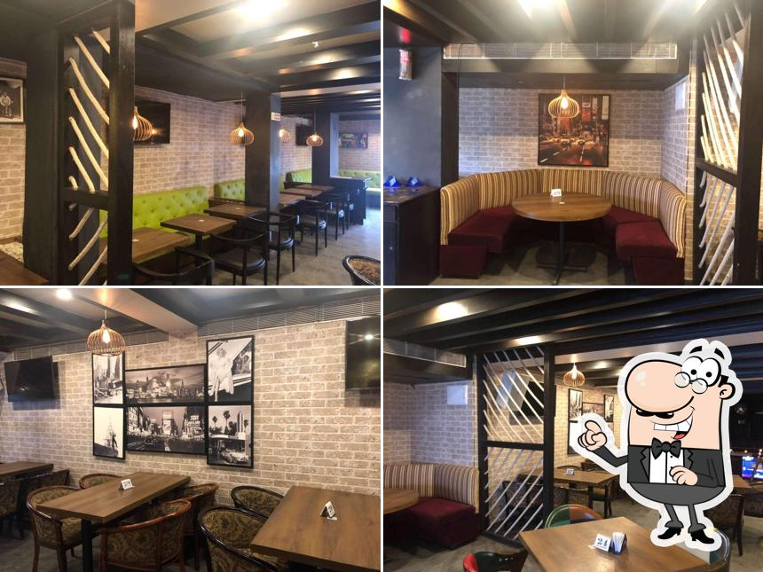 Take a seat at one of the tables at UG Cafe & Bar - Hotel Hindustan International