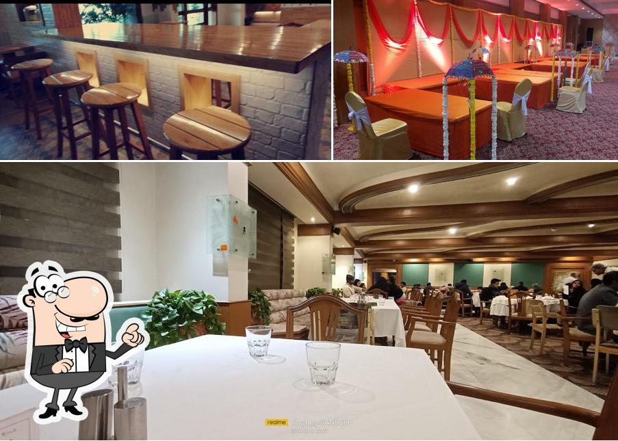 Take a seat at one of the tables at Shreemaya Residency Restaurant