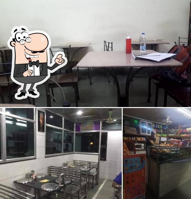 Take a seat at one of the tables at Sahajanand Restaurant