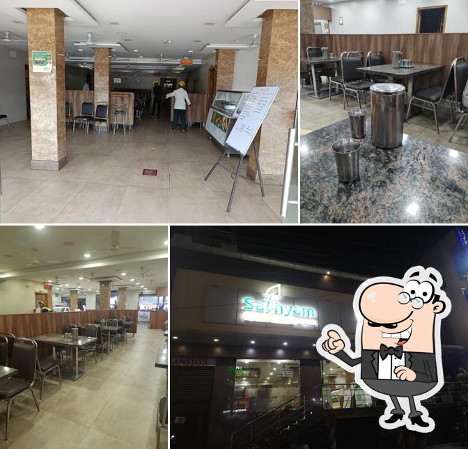 Take a seat at one of the tables at Sathyam Vegetarian Restaurant