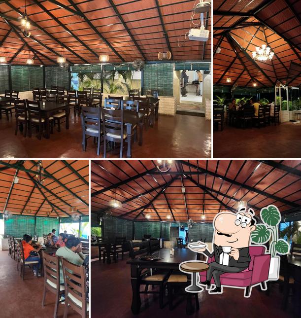 Take a seat at one of the tables at New Aroma Multi-Cuisine Restaurant