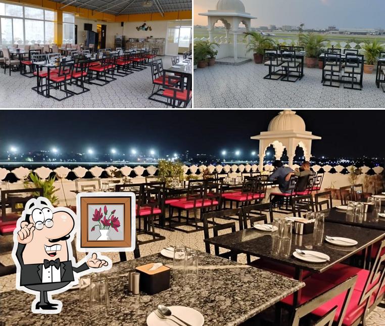 Take a seat at one of the tables at Hawai Chhatri Roof Top Restaurant
