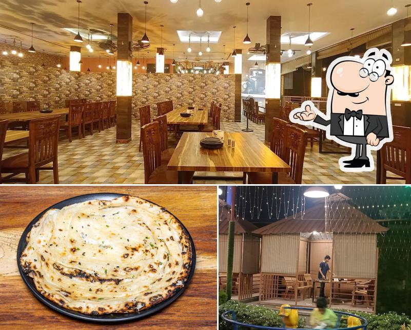 Take a seat at one of the tables at QASBA DHABA & RESTAURANT
