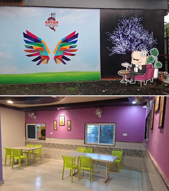 Take a seat at one of the tables at Aryan Veg-Nonveg Restaurant