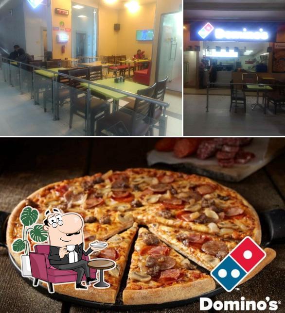 The image of interior and pizza at Domino's Pizza