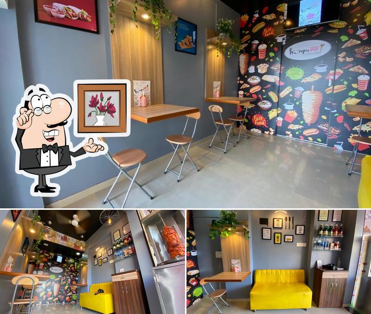 Take a seat at one of the tables at Hungry kya, यहाँ Aao भूख Mitao