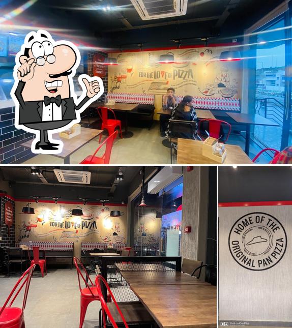 Take a seat at one of the tables at Pizza Hut Shivanand Nagar, Dharwad