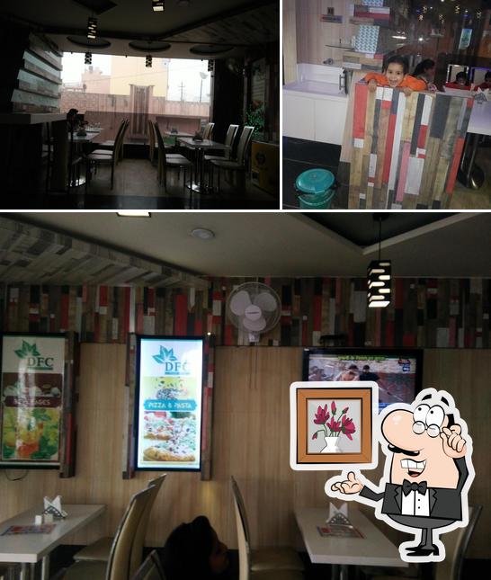 Take a seat at one of the tables at DFC Pure Veg. Restaurant