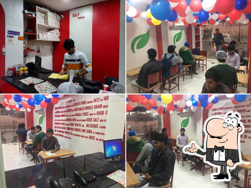 Take a seat at one of the tables at Redinnox Pizza Rohtak