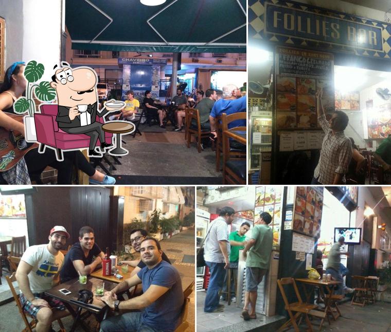 Sente em uma das mesas no Follies Bar