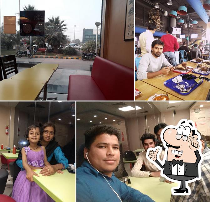 Take a seat at one of the tables at Domino's Pizza Omaxe Mall, Sector 49, Gurugram
