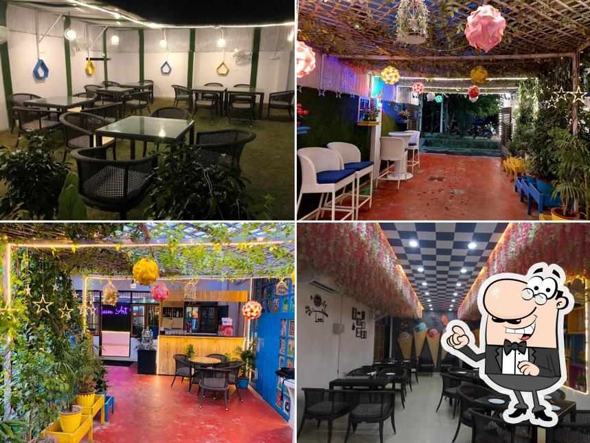 Take a seat at one of the tables at Dream Art Cafe Banquet & Restaurant - Jankipuram