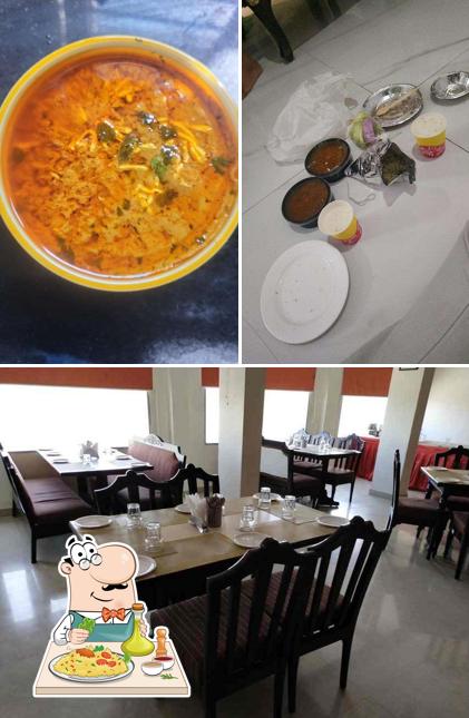 Among various things one can find food and dining table at Rasoi Restaurant - Hotel Relax Inn