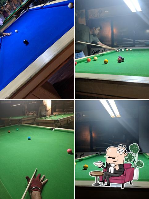 Take a seat at one of the tables at 6 POCKET's Snooker Club & CafeRoom Snooker Club in Vadodara