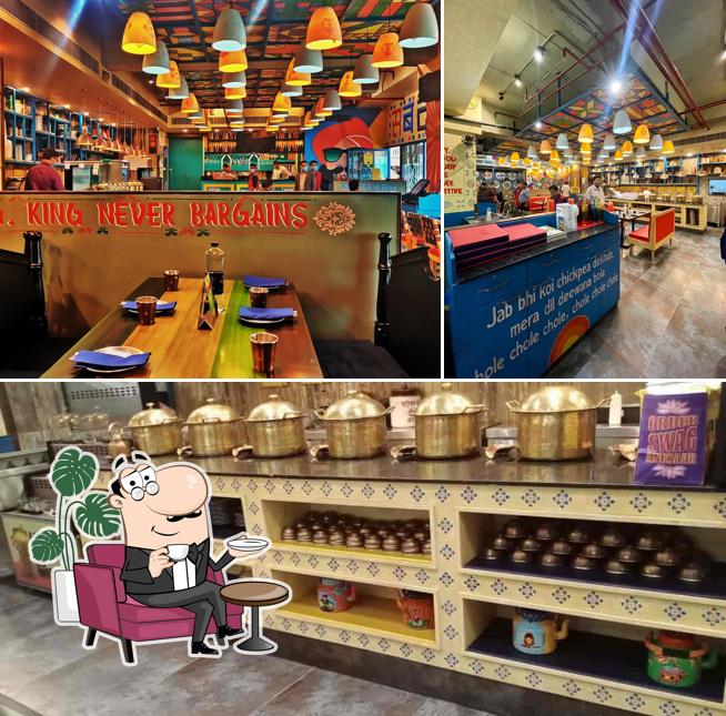 Take a seat at one of the tables at Dhaba Estd 1986 Delhi, Guwahati