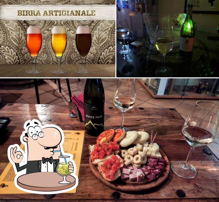 Guarda la foto che mostra la bevanda e tavolo da pranzo di Enoteca Bottega Mediterranea