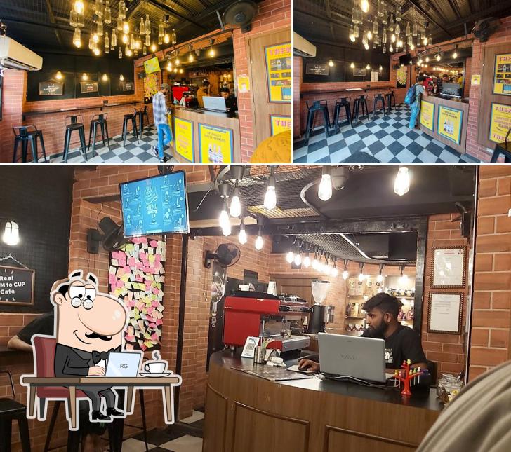 Take a seat at one of the tables at Theka Cafe Maninagar