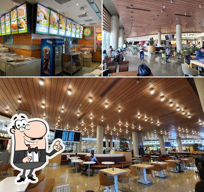 Take a seat at one of the tables at Food court, Departure terminal 2