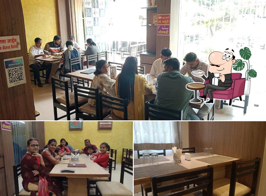 Take a seat at one of the tables at Bansuri Pure Veg Restaurant