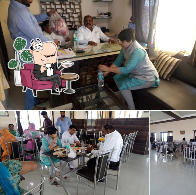 Take a seat at one of the tables at Hotel Sai Sagar Pure Veg and Lodge