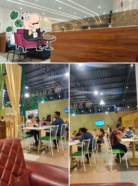 Take a seat at one of the tables at Shivarsh Veg Restaurant & AC Banquet
