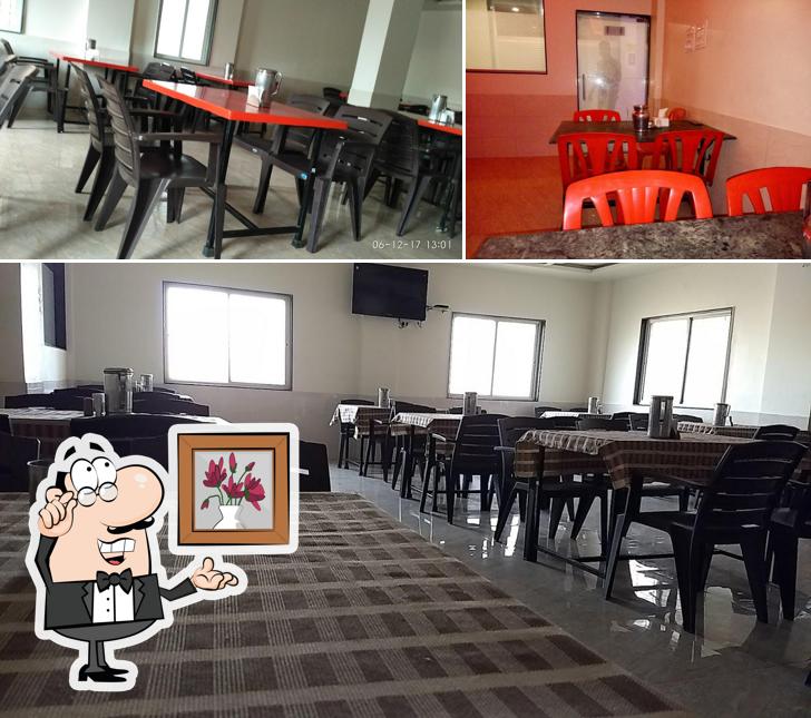 Among various things one can find interior and dining table at Hotel Atharva Family Restaurant & Bar