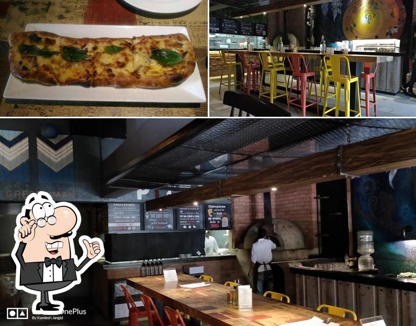 This is the picture displaying interior and pizza at The Greedyman Pizzeria