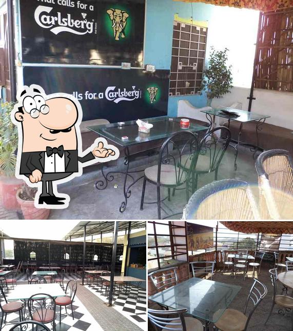 Take a seat at one of the tables at Rajwada Roof Top Restaurant