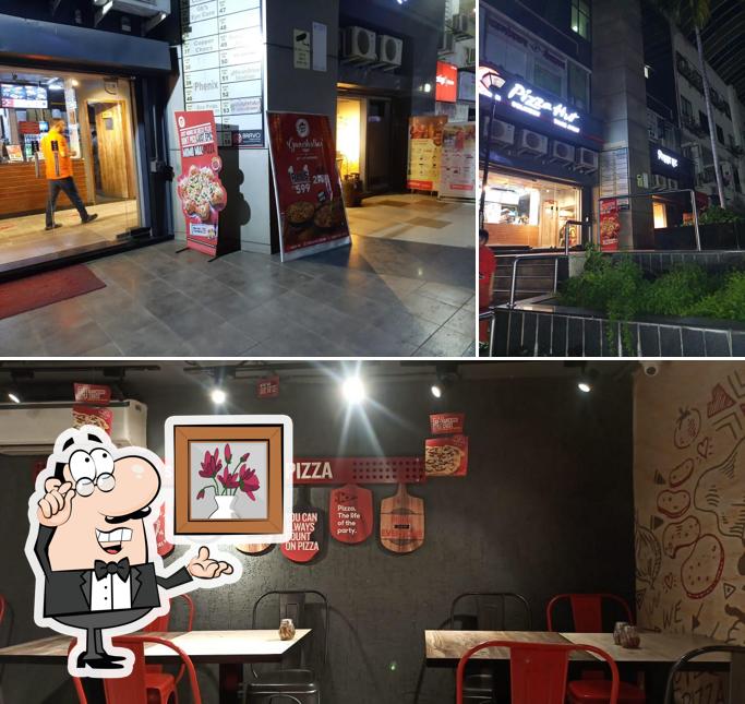 Take a seat at one of the tables at Pizza Hut Shoppers Orbit Vishrantwadi, Pune