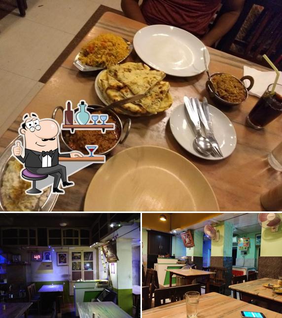 Take a seat at one of the tables at ADARSHA HINDU HOTEL