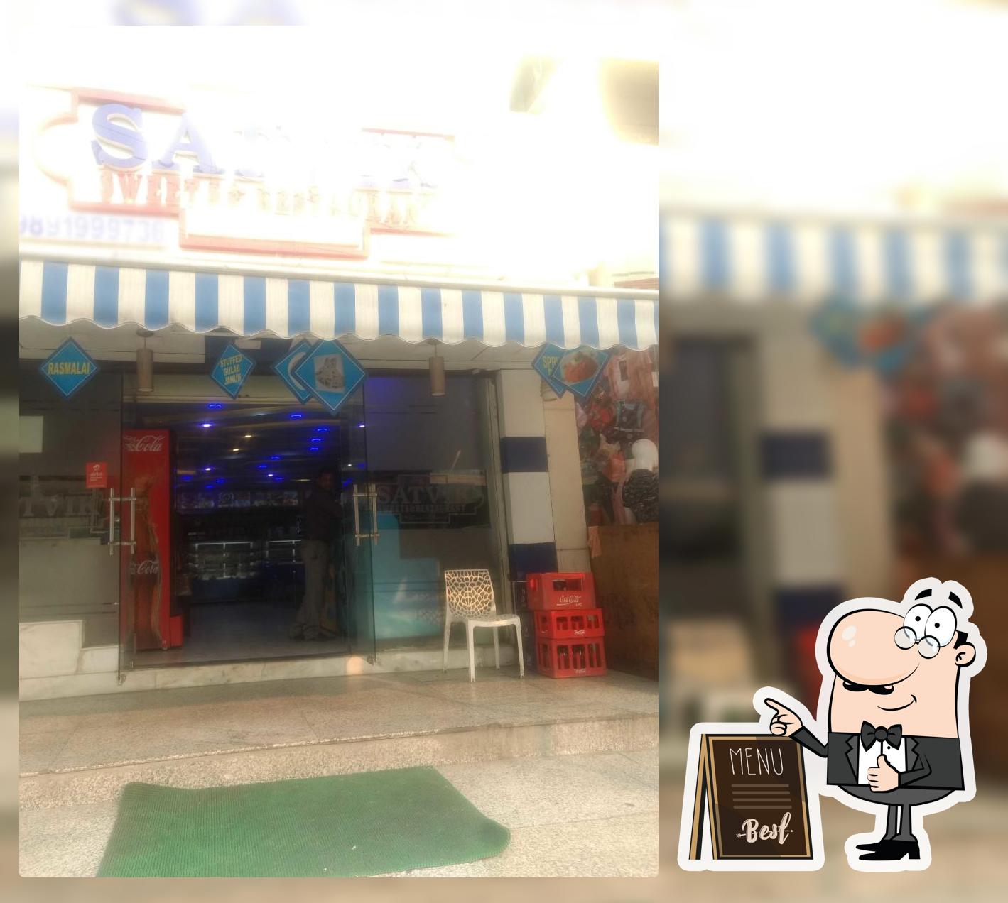 Take a seat at one of the tables at Satvik Sweets & Restaurant