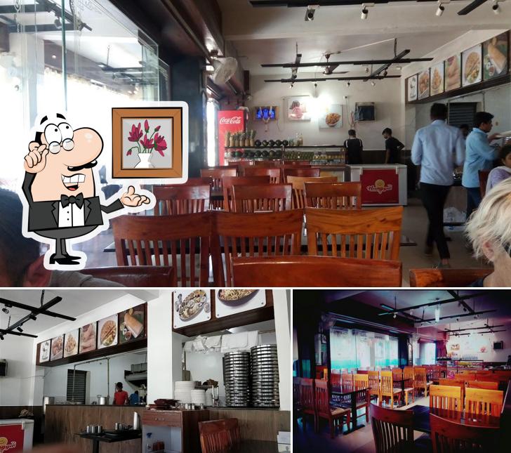 Take a seat at one of the tables at Ambika Upahar Udupi Vegetarian Restaurant