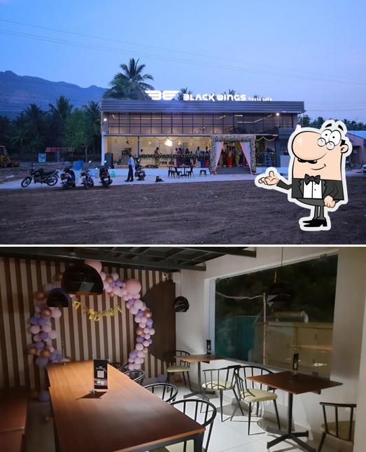 Take a seat at one of the tables at Black Wings Resto Cafe - Ariyanur
