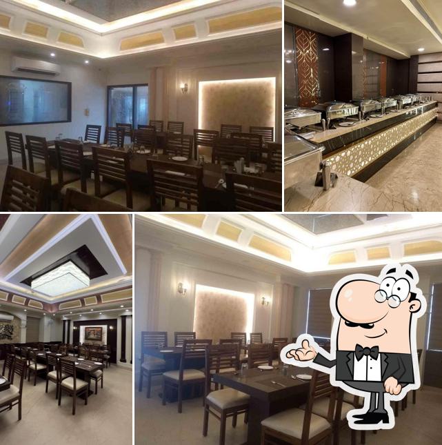 Take a seat at one of the tables at Hotel Grand Safari & Restaurant