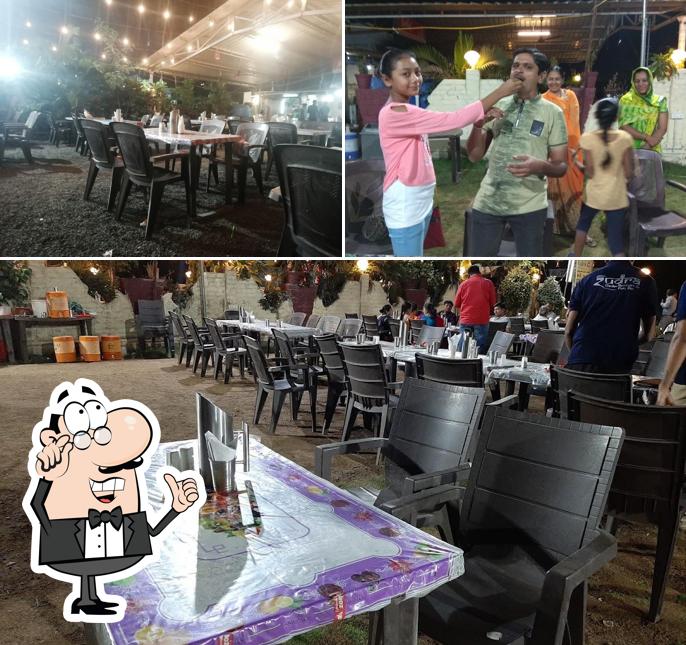Take a seat at one of the tables at Rudra Garden Restaurant & Party Plot