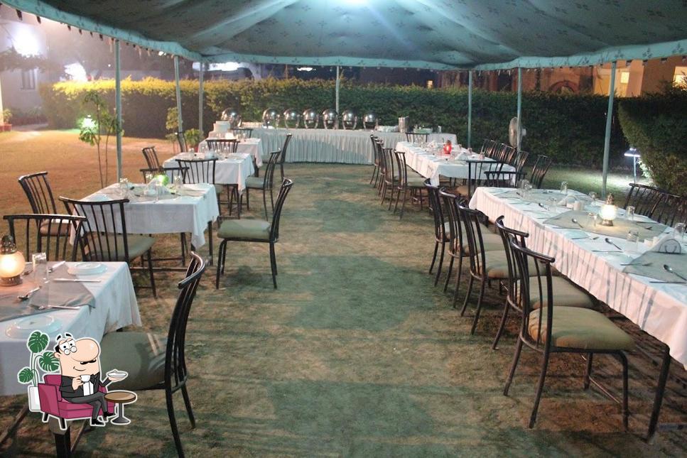 Take a seat at one of the tables at Restaurant Aroma - Veg & Non Veg Restaurant Udaipur, Multi Cuisine Restaurant in Udaipur, Laal Maas, Rajasthani Food