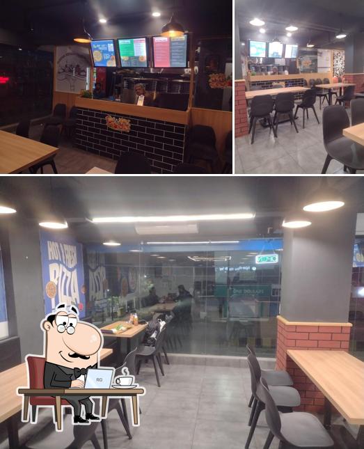 Take a seat at one of the tables at Spedito Pizzeria Jamnagar