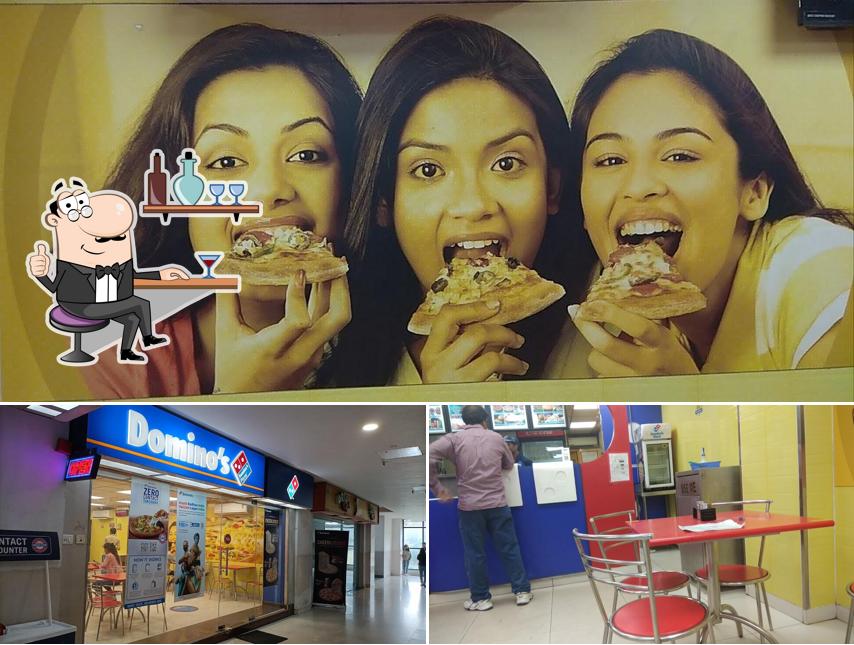 Check out the image depicting interior and food at Domino's Pizza Bank More, Dhanbad