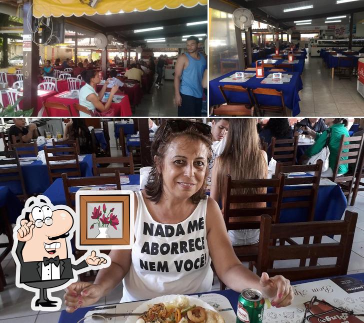 Sente em uma das mesas no Restaurante Do Pingo