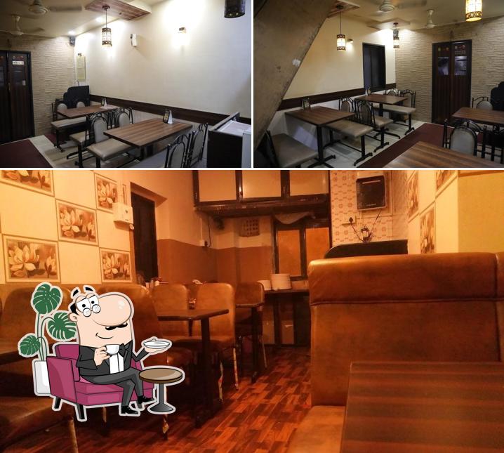 Take a seat at one of the tables at Jai Malhar Hotel and Caterers